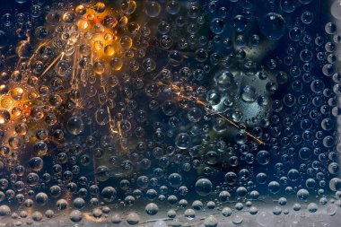 Şeffaf su damlaları ışık parlamalarıyla aydınlatılır ve bir turkuaz zemin üzerinde yer alır. Uzay soyutlaması. 3 Boyutlu Hazırlama.