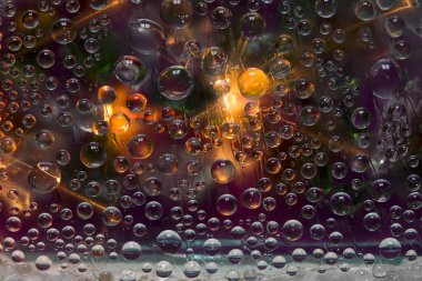 Şeffaf küreler bir ışık parlamasıyla aydınlatılır ve yeşil-mor bir zemin üzerinde yer alırlar. Uzay soyutlaması. 3 Boyutlu Hazırlama.