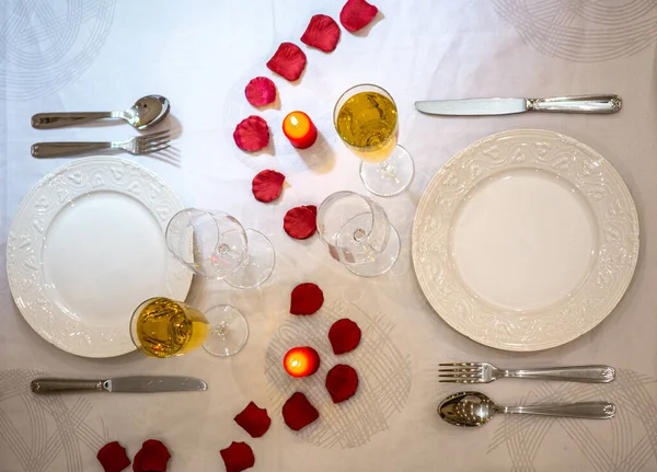romantic dinner setup, red decoration with candle light in a restaurant. Selective focus. Vintage color. Luxury romantic candlelight dinner table setup for couple on Valentine\'s day with Champagne.