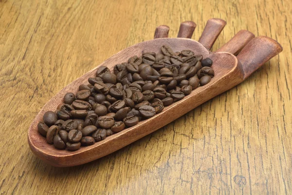 Coffee beans and an old wooden scoop — Stock Photo, Image