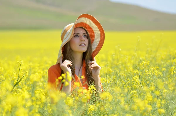 Beautiful woman on blooming rapeseed field — Stock Photo, Image