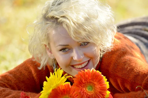 Güzel bir kadın açık portre güneşli bir gün ve kırmızı çiçekler — Stok fotoğraf