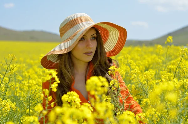 美丽的女人，在油菜花盛开的田 — 图库照片