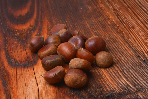 Chestnuts on wooden background — Stock Photo, Image