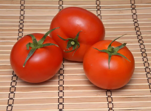 Tomatoes on a natural bamboo table mat — Stock Photo, Image