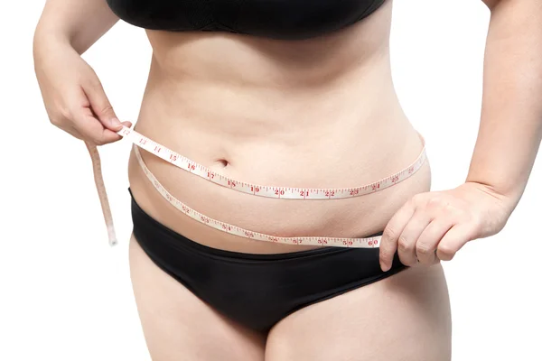 Жінка показує тіло жиру в чорному бюстгальтері білизни на білому ізольовані — стокове фото