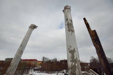 Eski bir binanın kalıntılarının üzerinde kara bulutlar, dış detaylar, yakın sütunlar olan dramatik gökyüzü. Geleneksel Sovyet mimarisi, geçmiş, tarih. Rusya 'da ekonomik düşüş. Kış şehri