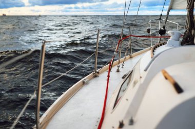 Gün batımında açık denizde yelken açmak. Güverteden pruvaya, direğe ve yelkenlere yakın görüntü. Dramatik fırtınalı gökyüzü, kara bulutlar, kış kasırgası, sert hava. Destansı deniz manzarası. Kuzey denizi, Norveç