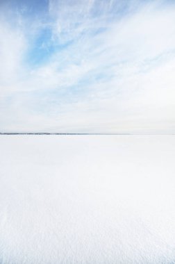 Donmuş karla kaplı göl, açık mavi gökyüzünün altında, sirrus bulutlarıyla. Taze kar dokusu. Kuzey Kutbu, Laponya. Küresel ısınma, kış sporu ve balıkçılık, çevre koruma teması