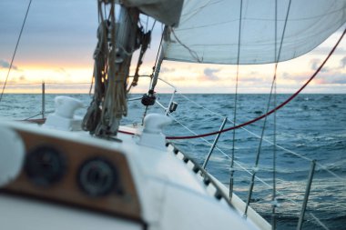 Gün batımında açık denizde yelken açmak. Güverteden pruvaya, direğe ve yelkenlere yakın görüntü. Dramatik fırtınalı gökyüzü, kara bulutlar, kış kasırgası, sert hava. Destansı deniz manzarası. Kuzey denizi, Norveç