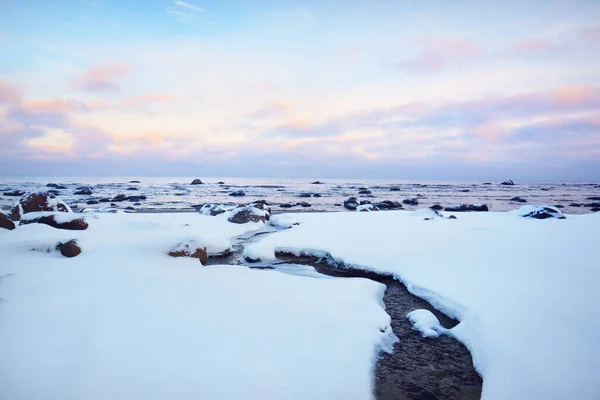 日没の雪に覆われたバルト海沿岸の景色 水の中の石を閉じる カラフルな雲と澄んだ青い空 見事な雲景だ 暖かい夜の光 牧歌的な冬のシーン ラトビアのカルテネ — ストック写真