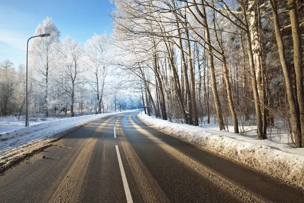 洗浄後の空のアスファルトの道路 通りの提灯を閉じます 新鮮な雪の中で車のトラック 背景に雪に覆われた森とフィールド 真っ青な空 冬の運転 フィンランド — ストック写真