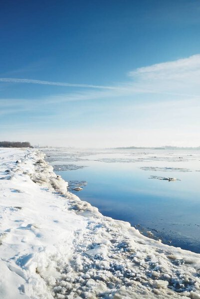 Frozen sea shore (promenade) on a clear day, breakwaters close-up. Blue sky. Winter landscape. Concept image. Seasons, nature, ecology, environment, climate change, global warming