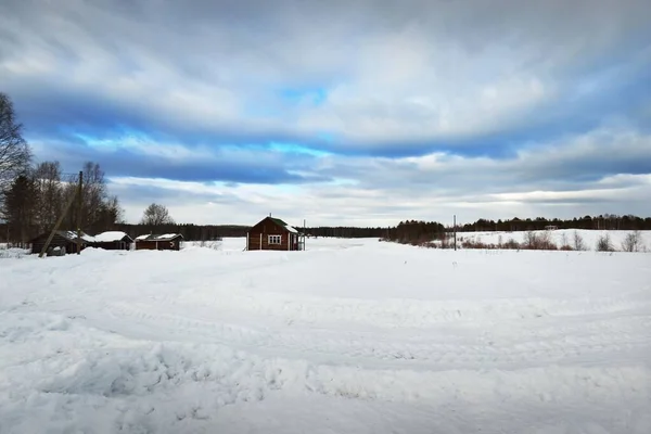 吹雪の後に雪に覆われたフィールドを空の道路 輝く雲と劇的な空 冬の田園風景 旅行先 エコツーリズム オフロード 遠隔村 — ストック写真