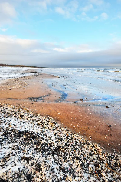 雪に覆われたバルト海の海岸からの眺め ラトビアのリガ湾 カラフルな劇的な雲の風景 ひどい天気 水が飛び散った 冬の観光 地球温暖化 — ストック写真