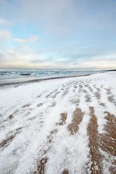夕暮れ時には雪に覆われたバルト海の海岸からの眺め ラトビアのリガ湾 カラフルな劇的な雲の風景 ひどい天気 波と水が飛び散った 冬の観光 地球温暖化のテーマ — ストック写真