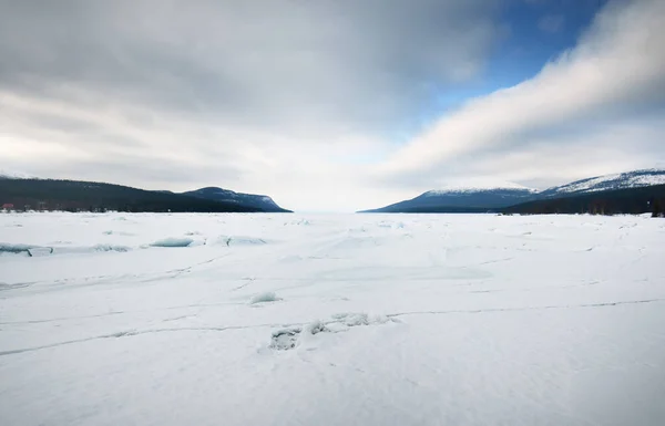 冰封的湖岸上的冰压脊 背景中的山峰 戏剧化的云雾 美丽的冬季风景 生态学 气候变化 全球变暖的概念 加拿大 — 图库照片