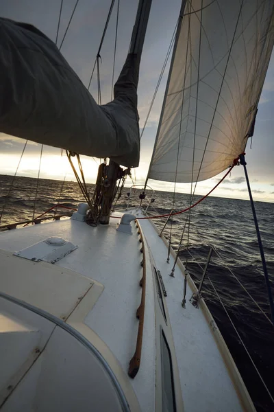 冬日日落时分 游艇在开阔的海面上航行 从甲板到船头 桅杆和船帆的近景 戏剧化的天空 金色的阳光穿过乌云 史诗般的海景挪威北海 — 图库照片