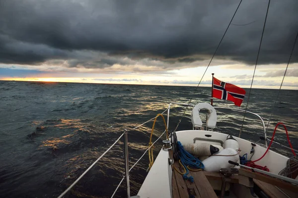冬の日に開かれた北海でヨットセーリング 木製のデッキからは ゴツゴツとした装備 ノルウェーの国旗が間近に見えます 劇的な嵐の空 暗い雲 叙事詩の海景 — ストック写真