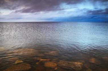 Letonya 'da fırtınadan sonra Baltık Denizi' nin üzerinde epik bir şekilde parlayan günbatımı bulutları. Dramatik deniz manzarası