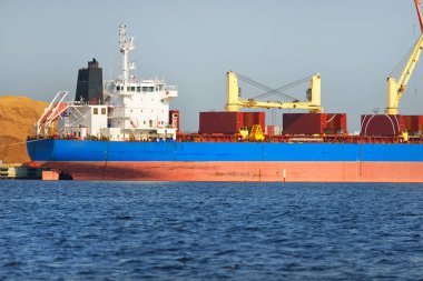 Kömür terminalinde büyük bir kargo gemisi (kargo gemisi), yakın plan. Arka planda iskele vinçleri. Krievu Adası, Riga, Letonya. Yük taşımacılığı, yakıt ve enerji üretimi, çevresel hasar