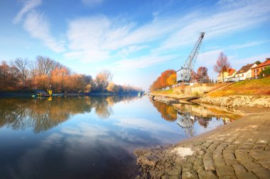 Ren nehrinin yanındaki parkta boş bir sokak. Seyahat yasağı ve koronavirüs (COVID-19) salgını nedeniyle kimse yok. Arka planda eski bir vinç var. Mainz, Almanya 'da karantina bölgesi