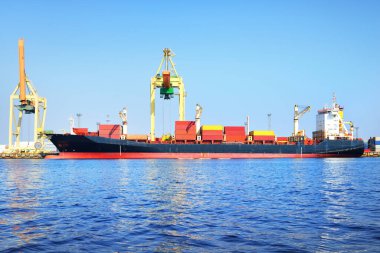 Büyük bir kargo gemisi ve Riga konteyner terminalinde bir vinç, yakın plan. Baltık Denizi, Letonya