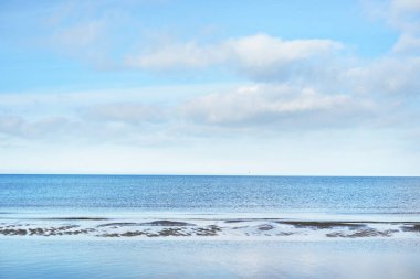 Güneşli bir yaz gününde kumlu Baltık kıyılarından panoramik manzara. Gök mavisi su ve açık mavi gökyüzü. Idyllic deniz manzarası. Letonya