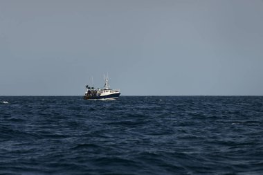 Açık bir Akdeniz 'de küçük bir balıkçı teknesi, yakın planda. Yattan bir manzara. Eğlence aktivitesi, spor ve eğlence, gıda endüstrisi, geleneksel zanaat, çevresel hasar kavramları