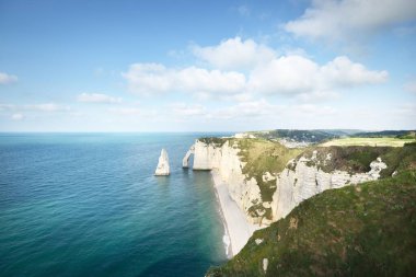 Gün batımında Etretat beyaz uçurumlarının manzaralı panoramik görüntüsü. Dramatik gökyüzü, gök mavisi su. Fransa, Normandiya 'da yaz tatili. Seyahat yerleri, ulusal dönüm noktaları, geziler, tarih.