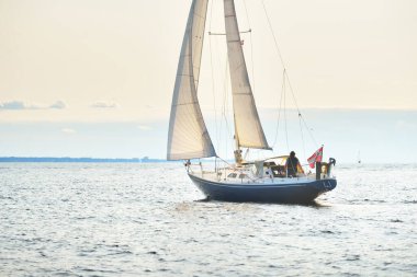 Açık bir Baltık Denizi 'nde yelkenli mavi bir yat, yakın plan. Dramatik bir gökyüzü. Riga Körfezi, Letonya. Gezi, spor, eğlence, boş zaman aktiviteleri.