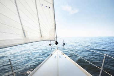 Güneşli bir yaz gününde beyaz bir yat denize açılıyor. Güverteden pruvaya, direğe ve yelkenlere kadar yukarıdan aşağı görüş. Dalgalar ve su sıçramaları. Açık mavi gökyüzü. Finlandiya Körfezi