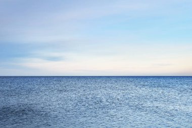 Renkli günbatımı gökyüzünün altında Baltık Denizi. Göz kamaştırıcı deniz manzarası. Beyaz bulutların arasından geçen altın günbatımı ışığı. Uzun pozlama. Huzur sahnesi. Riga Körfezi, Letonya