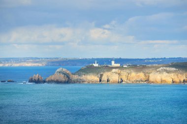 Pointe de Pen-Hir 'in kayalık sahili, uçurumlara yakın. Bulutlu mavi gökyüzü, masmavi su, fırtınalı dalgalar. Dramatik bulut manzarası. Crozon Yarımadası, Britanya, Fransa