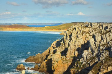 Pointe de Pen-Hir 'in kayalık sahili, uçurumlara yakın. Bulutlu mavi gökyüzü, masmavi su, fırtınalı dalgalar. Dramatik bulut manzarası. Crozon Yarımadası, Britanya, Fransa