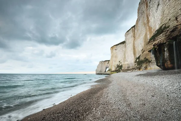 Etretat 'ın beyaz kayalıklarının manzarası panoramik alçak açılı. Dramatik gökyüzü, atmosferik manzara. Fransa, Normandiya 'da yaz tatili. Seyahat yeri, ulusal dönüm noktası, manzara, tarih.