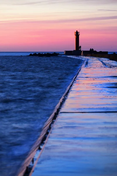 Couple People Standing Orange Lighthouse Colorful Sunset Sky Stunning Cloudscape — Stock Photo, Image