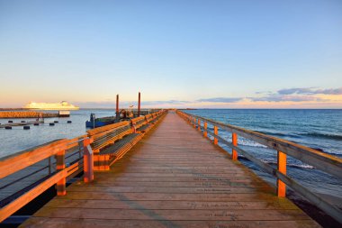 Boş bir ahşap iskele, yakın plan bank. İnsanlar seyahat yasağı ve koronavirüs (COVID-19) salgını nedeniyle evde kalıyorlar. Kapalı feribot bağlantısı. Ystad, İsveç karantina bölgesi