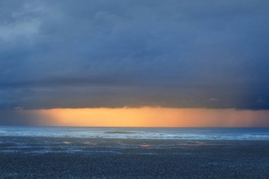 Günbatımında Dover (Pas de Calais) 'de Fransa kıyılarındaki Cap Blanc Nez' in uçurumuna yakın kumsalda. Dramatik akşam gökyüzü, fırtınadan sonra destansı renkli bulutlar. Seyahat, ekoloji teması