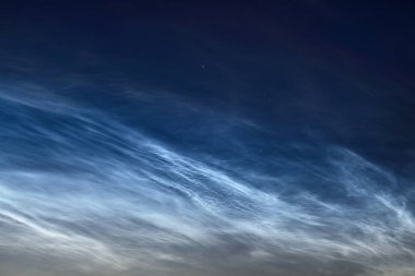 Finlandiya 'da yaz gündönümü gecesinde gece bulutları olan yıldızlı bir gökyüzü. Güzel akan ışık. Harika bir bulut. Doğal desen. Soyut sanat. Finlandiya