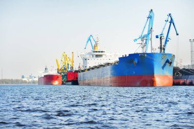 Kömür terminalinde büyük bir kargo gemisi (kargo gemisi), yakın plan. Arka planda iskele vinçleri. Krievu Adası, Riga, Letonya. Yük taşımacılığı, yakıt ve enerji üretimi, çevresel hasar