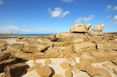 Güneşli bir günde, Lilia Körfezi 'nin Rocky kıyısında, Le Vierge deniz fenerinin yanında. Kadim taşlara yakın çekim. Plouguerneau, Finistre, Brittany, Fransa. Seyahat yerleri, ulusal dönüm noktaları.
