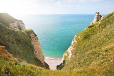 Gün batımında Etretat beyaz uçurumlarının manzaralı panoramik görüntüsü. Dramatik gökyüzü, gök mavisi su. Fransa, Normandiya 'da yaz tatili. Seyahat yerleri, ulusal dönüm noktaları, geziler, tarih.