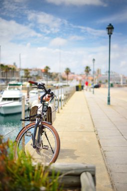 Bicycle parked on the promenade on a clear day, close-up. Yacht marina in Cascais, Portugal. Sport, leisure activity, recreation, vacations, travel destinations, alternative transportation theme