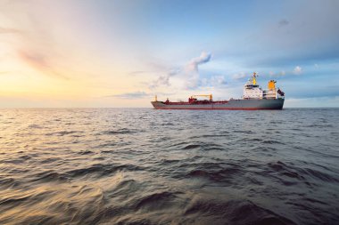 Büyük gri bir tanker gün batımında Europort 'tan denize açılacak. Renkli akşam bulutları. Rotterdam, Hollanda. Lojistik, ticaret, küresel iletişim teması