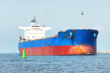 Baltık Denizi 'nden Letonya' nın Riga limanına giden büyük mavi yük gemisi (gemi). Yattan bir manzara. Genel kargo. Küresel iletişim, lojistik, endüstri, nakliye