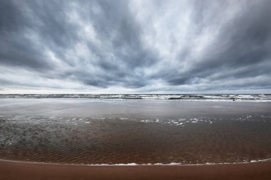 Kışın Kuzey Denizi 'nin yukarısında fırtına bulutları, uzun pozlama. Dramatik gökyüzü, dalgalar ve su sıçramaları. Koyu deniz manzarası. Hollanda
