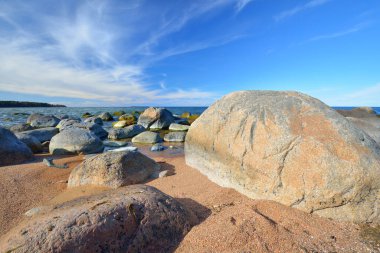 Baltık Denizi 'nin kayalık kıyıları açık mavi gökyüzünün altında, sirrus bulutlarıyla. Kadim taşlara yakın çekim. Bahar. Kasmu doğa rezervi, Estonya. Ekoloji, çevre koruma, eko turizm kavramları