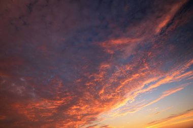 Renkli pembe, kırmızı, turuncu ve altın renkli sirrus bulutlarıyla gün batımı gökyüzü. Soyut doğal desen, doku, yakın plan. Sanat, meteoroloji, ekoloji, iklim değişikliği, din, cennet kavramları