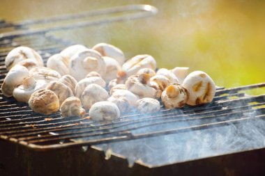 Kömür mantarı ızgarası ve yakın plan sigara. Mutfak, sağlıklı beslenme, yaşam tarzı, organik, vejetaryen, vegan yemekleri, yemek pişirme, yaz tatilleri teması
